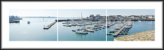 Un bateau de pêche entre au port de Concarneau devant le port de plaisance